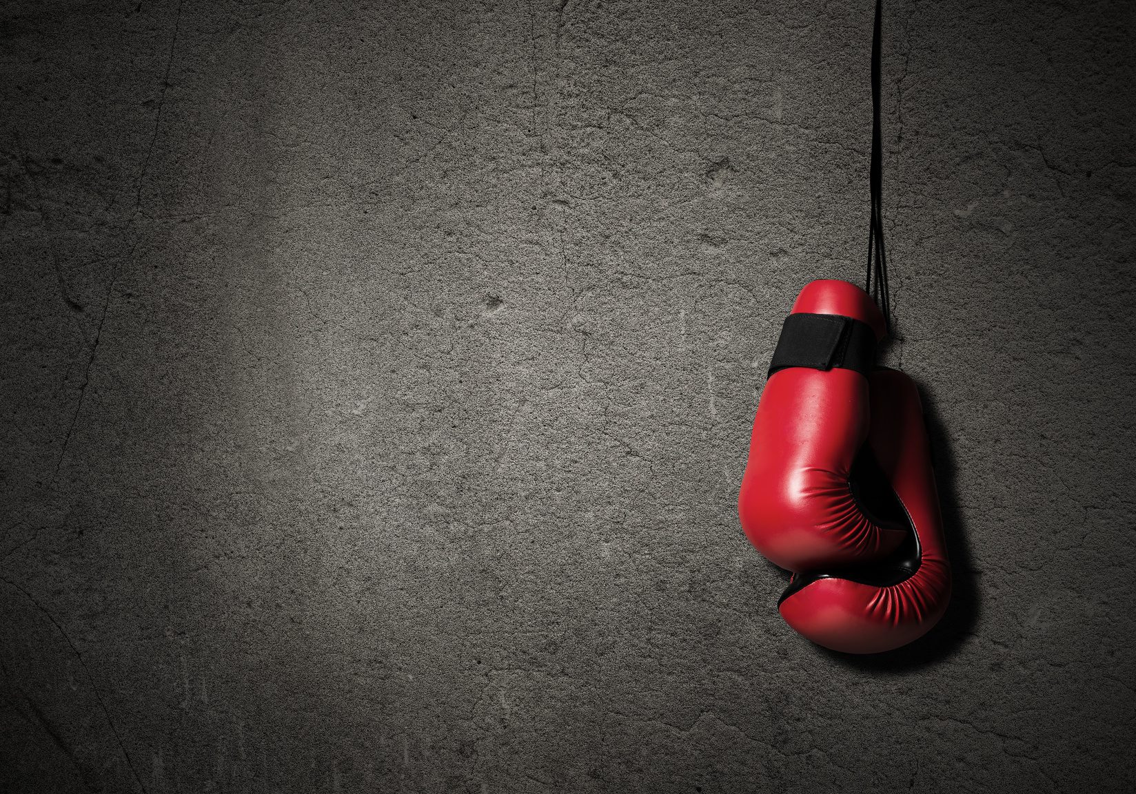 Boxing gloves hanging nailed to wall as concept of retirement